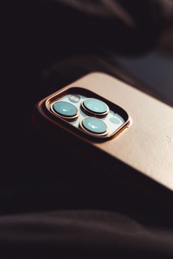 Artistic close-up of a smartphone camera lens with moody lighting, highlighting modern technology.